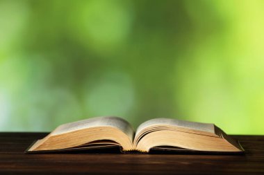 İncil ahşap masada bulanık yeşil arka plana karşı, yazı için boşluk. Hıristiyanlık Dini