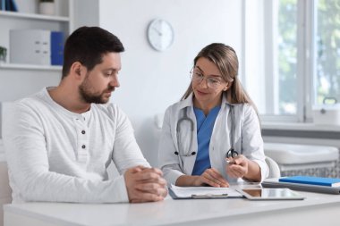 Hastanedeki beyaz masada hastayla çalışan profesyonel bir doktor.