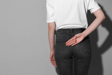 Gri arka planda, arka planda avucunu açık gösteren bir kadın. Metin için boşluk