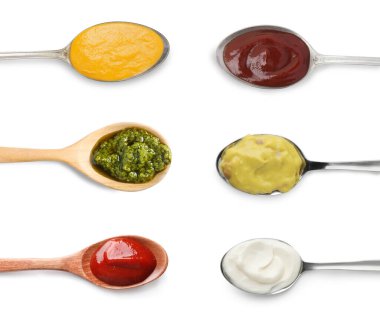 Beyaz, üst görünümde izole edilmiş kaşıklardaki farklı soslar.