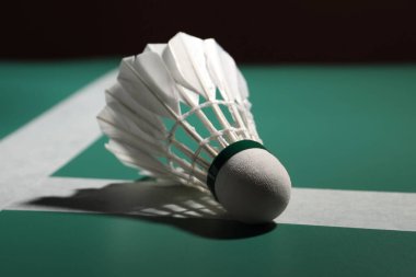 Tüylü badminton mekiği yeşil masada, yakın plan.