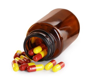 Dağılmış antibiyotik hapları ve beyaz şişeye izole edilmiş şişe.