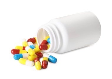 Dağılmış antibiyotik hapları ve beyaz şişeye izole edilmiş şişe.