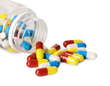 Dağılmış antibiyotik hapları ve beyaz şişeye izole edilmiş şişe.