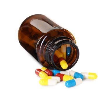 Dağılmış antibiyotik hapları ve beyaz şişeye izole edilmiş şişe.