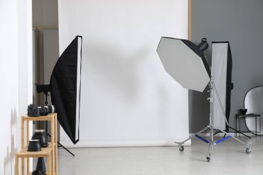 Stüdyoda beyaz fotoğraf ve profesyonel ışıklandırma ekipmanları