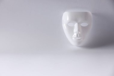 Beyaz arka planda plastik yüz maskesi, metin için boşluk. Tiyatro performansı