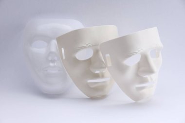 Beyaz arka planda plastik yüz maskeleri. Tiyatro performansı