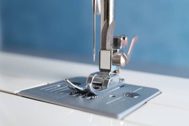 Hafif arkaplanda beyaz dikiş makinesi, yakın plan