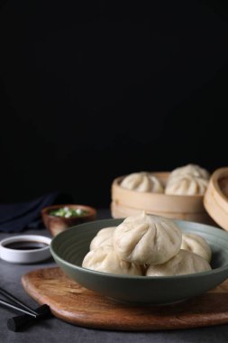 Gri masadaki kasede lezzetli bao çörekleri (baozi), yakın plan. Metin için boşluk