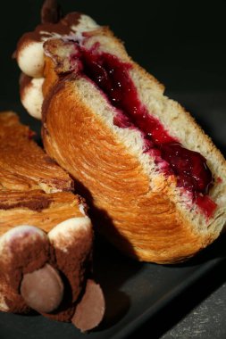 Masada reçelli, kremalı ve çikolata parçalı yuvarlak kruvasan, yakın plan. Lezzetli puf böreği