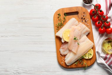 Çiğ balık parçaları, limon, domates ve yağ beyaz ahşap masa, üst manzara. Metin için boşluk