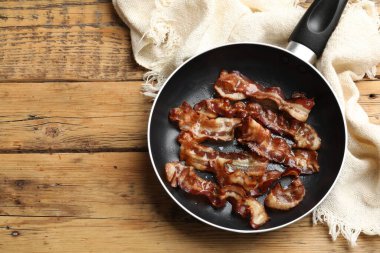 Ahşap masada tavada leziz pastırma dilimleri, üst manzara. Metin için boşluk