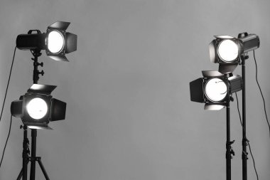 Stüdyoda gri fotoğraf ve profesyonel ışıklandırma ekipmanları