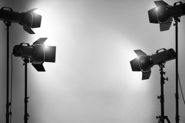 Stüdyoda gri fotoğraf ve profesyonel ışıklandırma ekipmanları