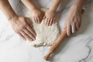 Baba ve çocuk beyaz masada para kazanıyor.