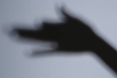 Gri arka plandaki köpek gibi elin gölgesi