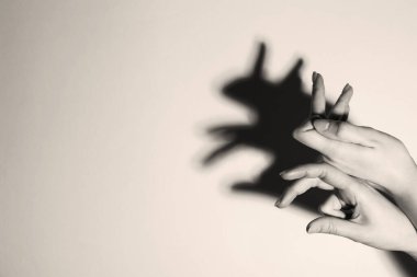 Gölge kuklası. Kadın arka plandaki tavşan gibi el hareketi yapıyor, mesaj için yeri olan bir yere yakın çekim yapıyor. Siyah ve beyaz etkisi