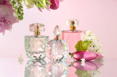 Ayna yüzeyinde pembe arka planda lüks parfümler ve çiçek dekoru