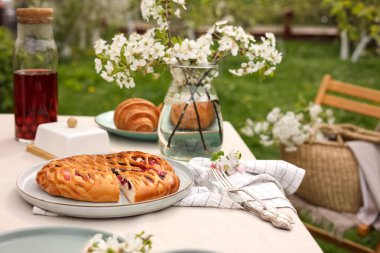 Güzel bahar çiçekleri, meyve suyu ve turtayla süslü masa.