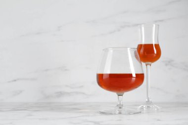 Beyaz mermer masada gözlüklü leziz likörler, metin için yer.