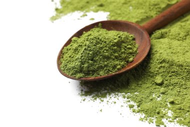 Yeşil kibrit tozu ve ahşap kaşık beyaza izole edilmiş.