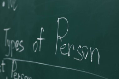 Yeşil tahtaya tebeşirle yazılmış İngilizce dil bilgisi kuralları, yakın plan