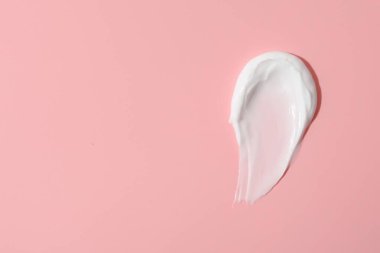 Pembe arka planda yüz kremi örneği, üst manzara. Metin için boşluk