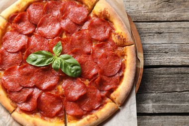 Ahşap masada nefis pepperonili pizza, üst manzara. Metin için boşluk