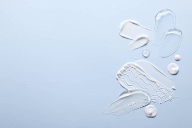 Açık mavi arka planda yüz kremi örnekleri, üst manzara. Metin için boşluk