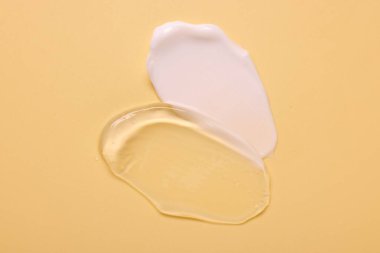 Soluk sarı arka planda yüz kremi örnekleri, üst manzara.