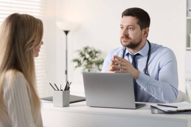 Hastanedeki beyaz masada hastayla çalışan profesyonel bir doktor.