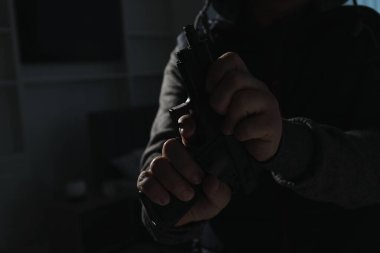 Yabancı evde silahlı tehlikeli bir suçlu, yakın plan. Silahlı soygun.
