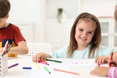 İçerideki masada resim yapan sevimli küçük çocuklar.