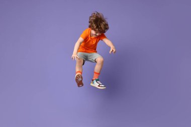 Mutlu küçük çocuk menekşe arka planda dans ediyor