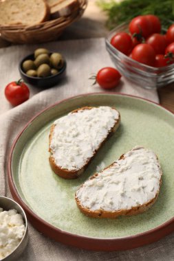 Lezzetli ricotta bruschetas ve ahşap masadaki ürünler.