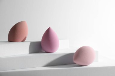 Beyaz arkaplanda makyaj süngerlerinin şık sunumu