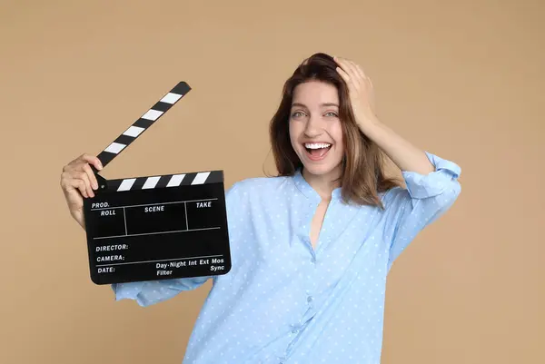 stock image Making movie. Happy woman with clapperboard on beige background