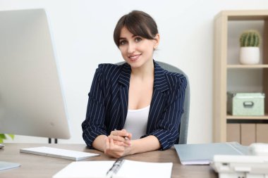 Portrait of smiling secretary at table in office