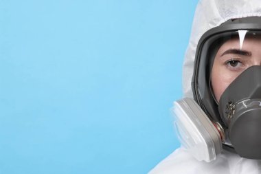 Açık mavi arkaplan üzerinde solunum cihazı ve koruyucu giysi işçisi, metin için boşluk