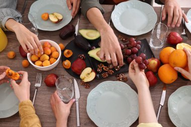 Ahşap masada vejetaryen yemekleri yiyen arkadaşlar, yakın plan.