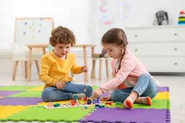 Anaokulundaki bulmaca minderinde matematik oyunu oynayan şirin çocuklar.
