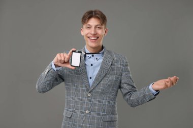 Happy man with blank badge on grey background