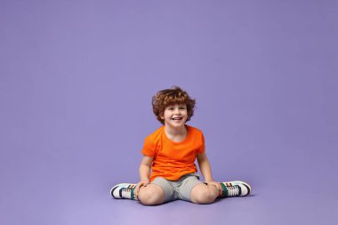 Mutlu küçük çocuk menekşe arka planda dans ediyor