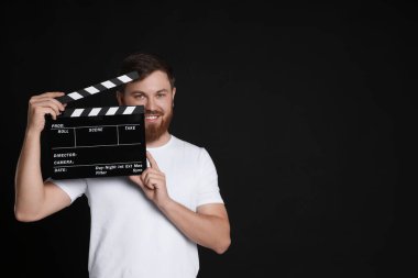 Film çekiyoruz. Siyah arka planı olan gülen bir adam. Metin için boşluk