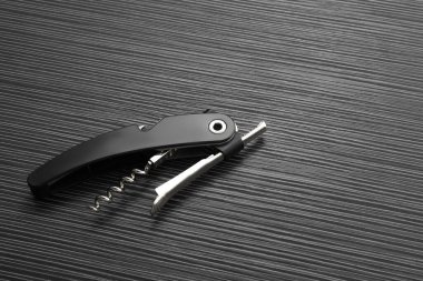 Siyah ahşap masa üzerinde bir tirbuşon (sommelier bıçak), üst manzara. Metin için boşluk