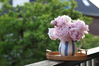 Balkon korkuluklarında vazoda duran güzel pembe şakayık çiçekleri. Metin için boşluk