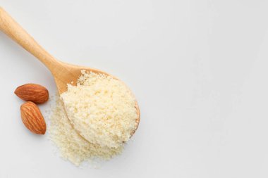 Taze badem unlu kaşık ve beyaz arka planda fındıklar. Metin için boşluk