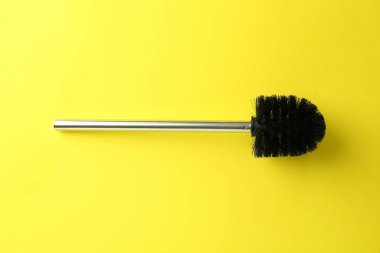 Sarı zemin üzerinde tuvalet fırçası, üst görünüm