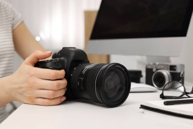 Beyaz masadaki kameralı fotoğrafçı, yakın plan.